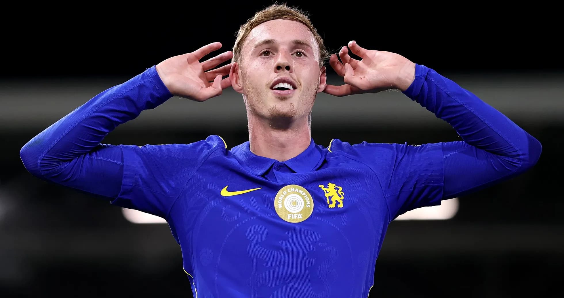 Player celebrating with hands behind ears in blue kit Player celebrating with hands behind ears in blue kit